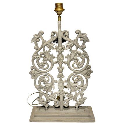 Kovová lampa inspirovaná tradiční indickou mříží, umístěná na pevném dřevěném podstavci.