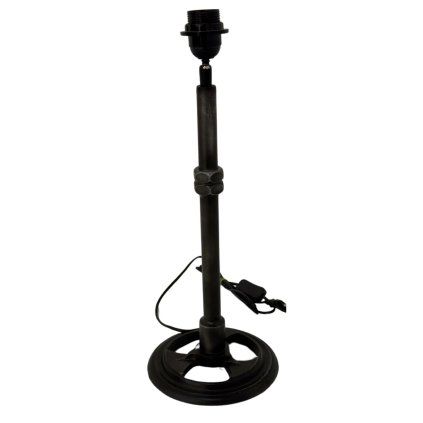 Lampa s robustním kovaným podstavcem, který dodává prostoru industriální šarm.