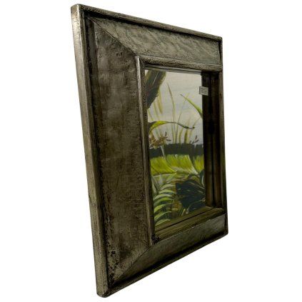 Zrcadlo s výrazným masivním kovovým rámem, které spojuje surovou sílu materiálu s nadčasovou elegancí.
