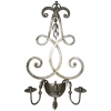 Dekorativní kovový svícen na stěnu s rustikálním vzhledem a elegantními křivkami.